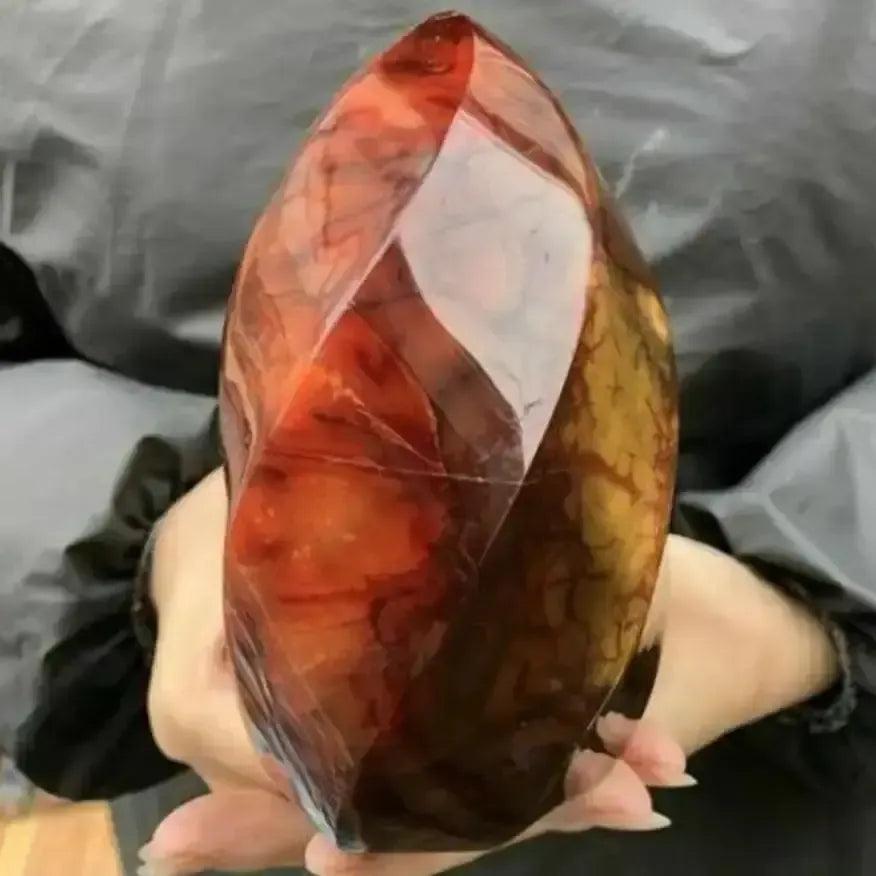 Vibrant Carnelian Crystal Flame, a hand-carved, polished orange-red stone boosting vitality and creativity.