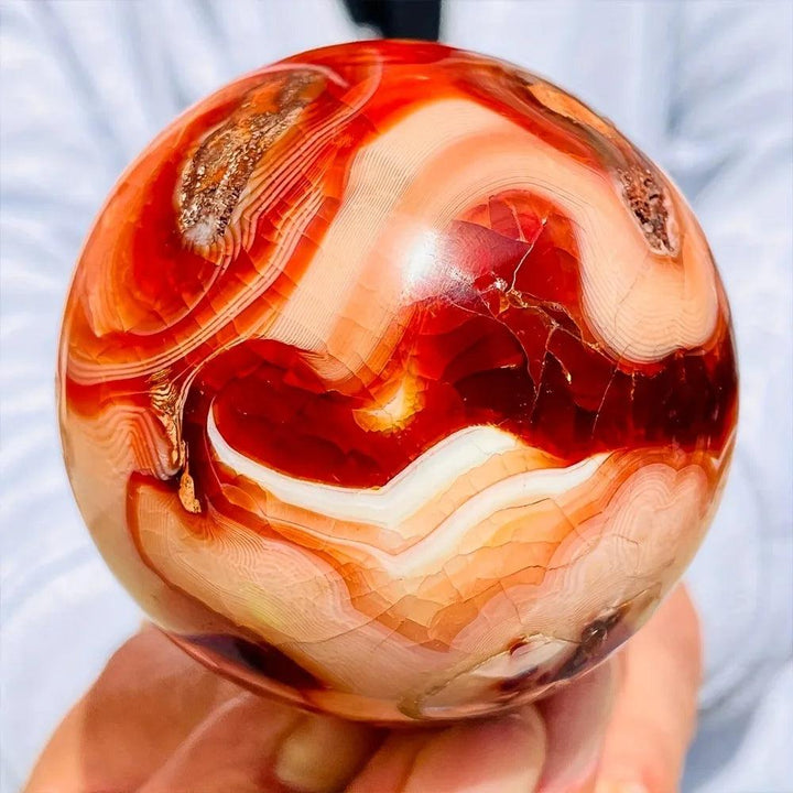 Warm, polished Carnelian Crystal Sphere with deep orange-red tones and natural agate banding, radiating energy.