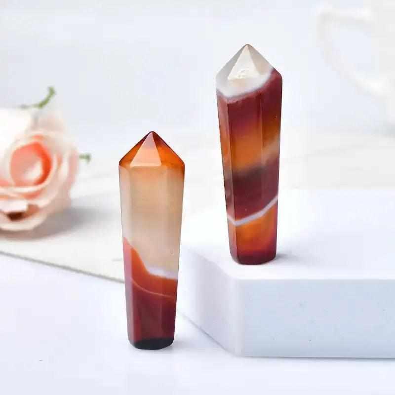 Polished 55mm hexagonal carnelian crystal point in warm orange and red tones for creativity and Sacral Chakra healing.