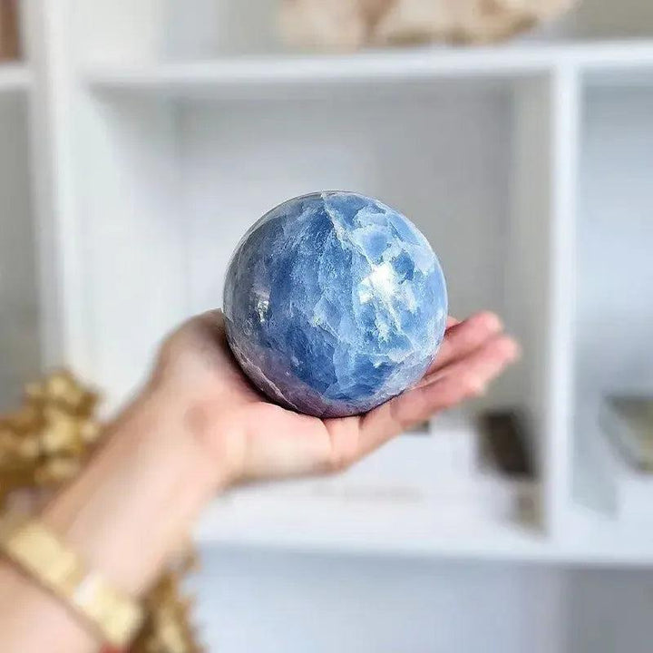 Hand-polished Celestite Crystal Sphere, showcasing soft blue hues and delicate crystalline structure for peace and spiritual connection.