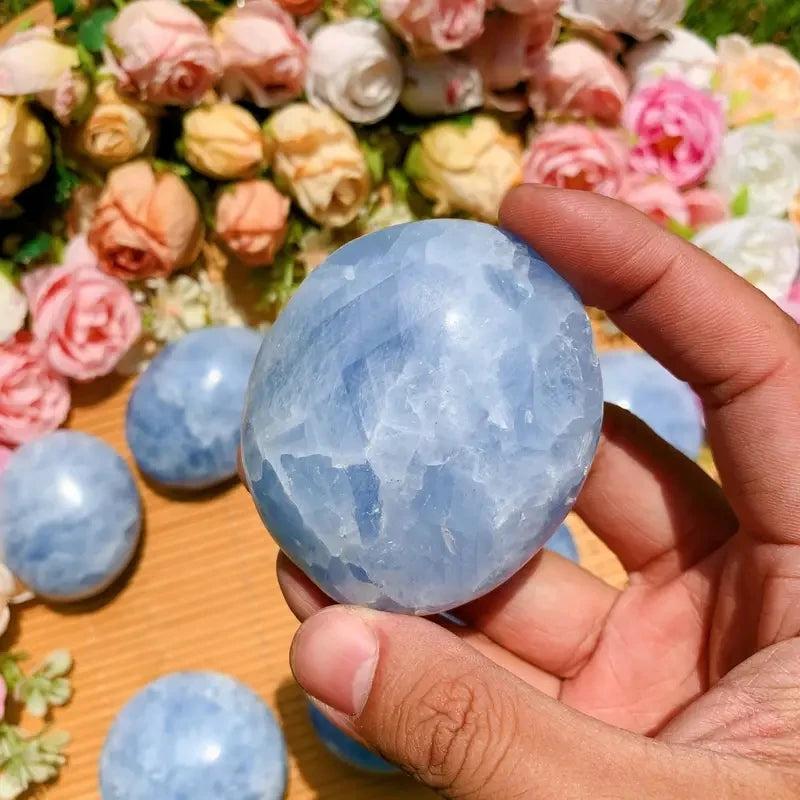 Polished sky-blue Celestite palm stone held in hand, perfect for calming meditation and Throat Chakra healing.