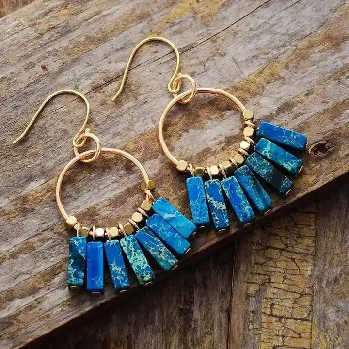 Gold-plated hoop earrings with vibrant blue Imperial Jasper rectangular beads for energy alignment and spiritual wellness.