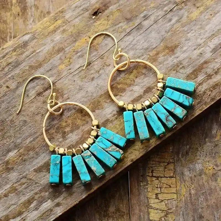 Gold-plated hoop earrings with vibrant turquoise bar beads, perfect for bohemian style and energy alignment.