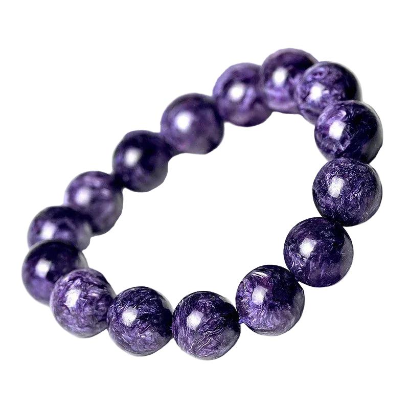 Charoite beaded bracelet with natural violet and lavender swirling patterns, round beads on an elastic band.
