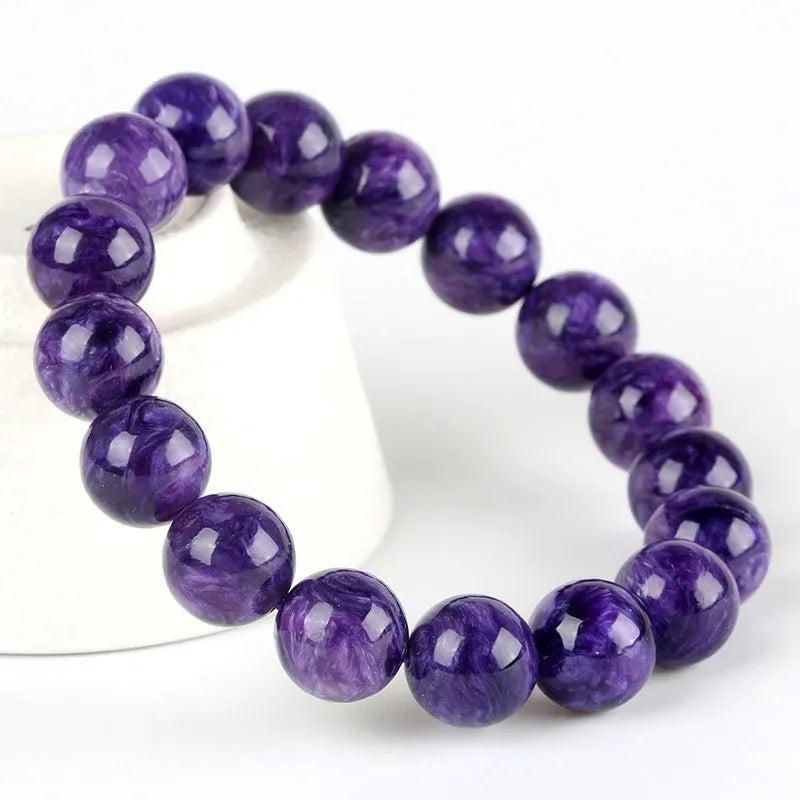 Natural Charoite beaded bracelet with swirling violet and lavender round beads on an elastic band.