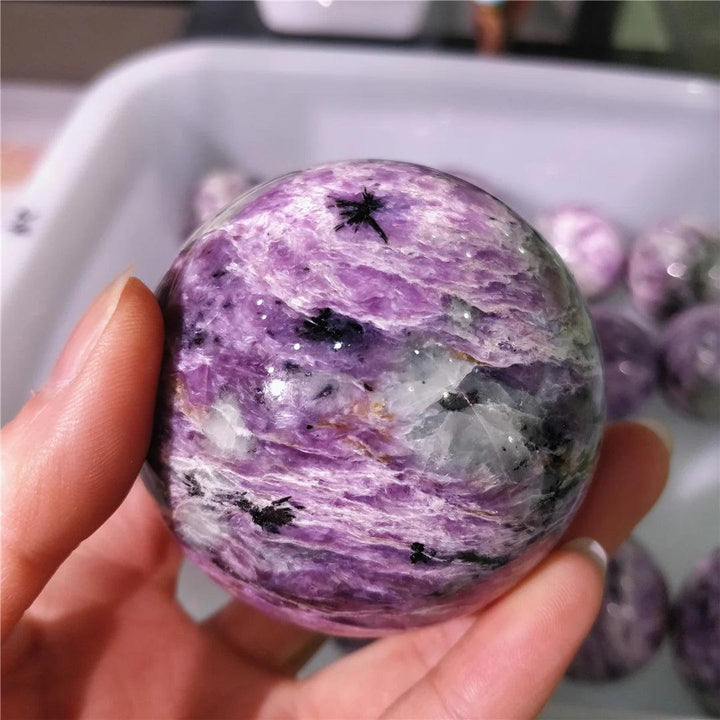 Rare Charoite crystal sphere with deep violet, lavender, and black swirls for spiritual growth and inner transformation.