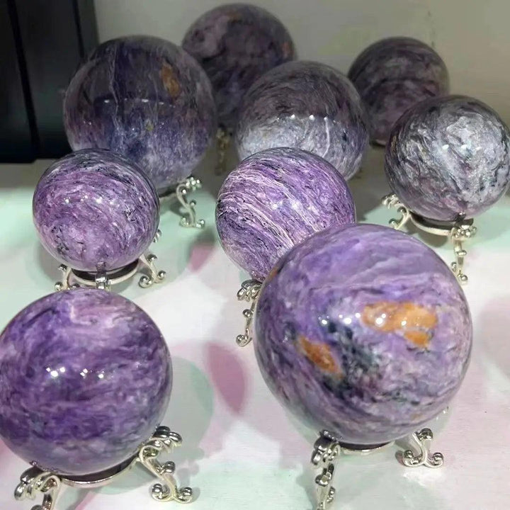 Rare Charoite crystal spheres featuring deep violet and lavender swirls for spiritual growth and inner transformation.