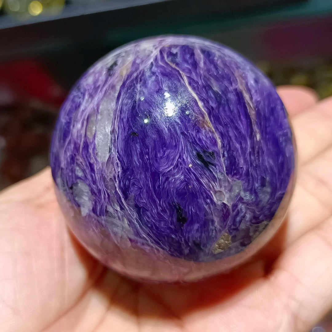 Polished Charoite sphere featuring vibrant violet swirls and white accents, perfect for spiritual transformation.