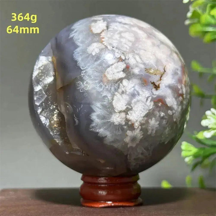 Polished Cherry Agate Crystal Sphere, 64mm, with white floral patterns, gray banding, and a wooden base.