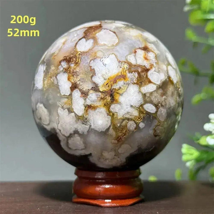 Cherry Agate Crystal Sphere, 52mm, with unique white, brown, and yellow banding, on a wooden display base.
