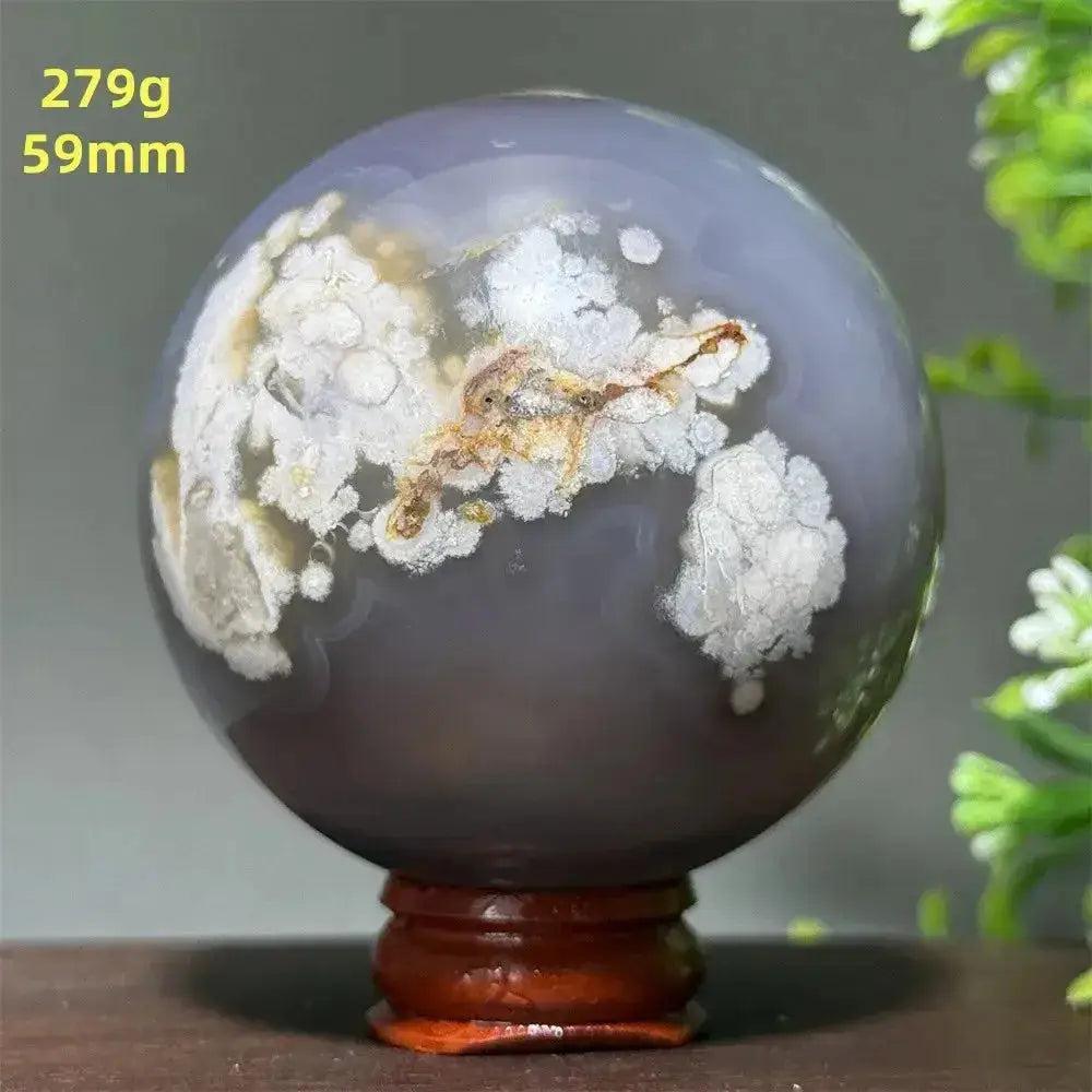 Polished gray Cherry Agate crystal sphere with white and brown inclusions on a wooden stand, 59mm, 279g.