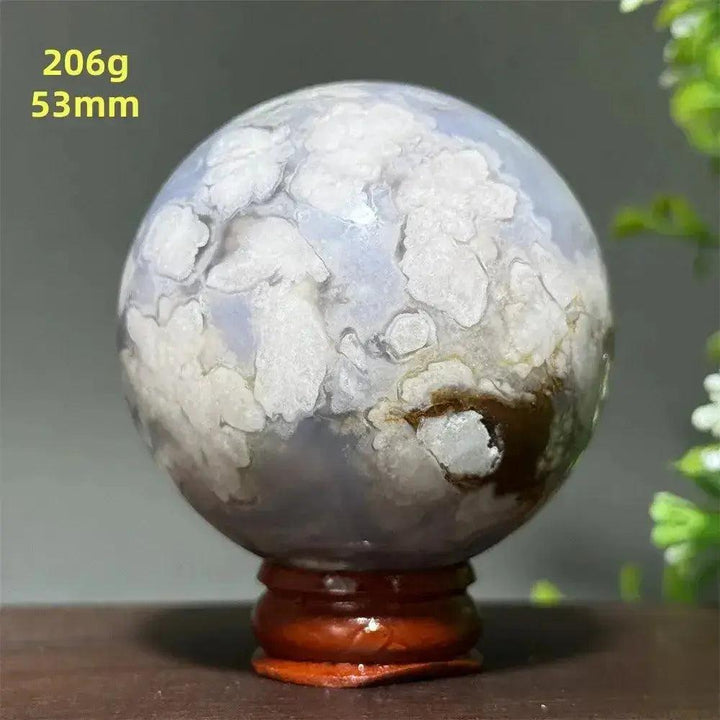 Polished Cherry Agate Crystal Sphere, 53mm, with unique white and brown banding on a wooden base.