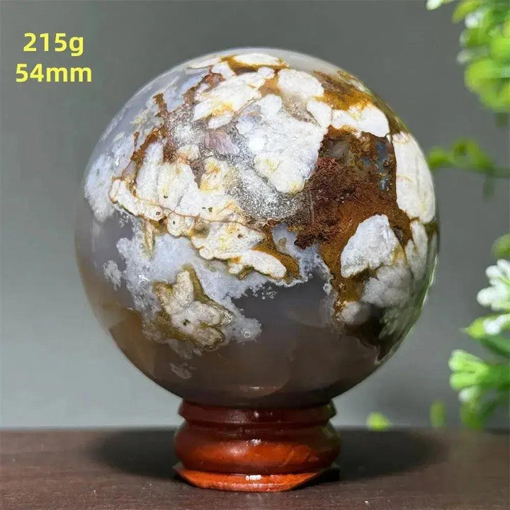 Polished Cherry Agate Crystal Sphere, 54mm, with unique white, brown, and gray banding on a wooden stand.