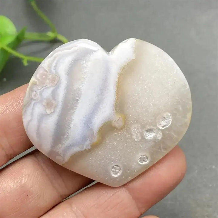 Polished Cherry Blossom Agate heart with delicate pink, white, and purple floral patterns, promoting emotional healing.