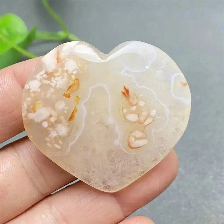 Polished Cherry Blossom Agate Heart with delicate pink and white floral patterns, promoting emotional healing and self-love.