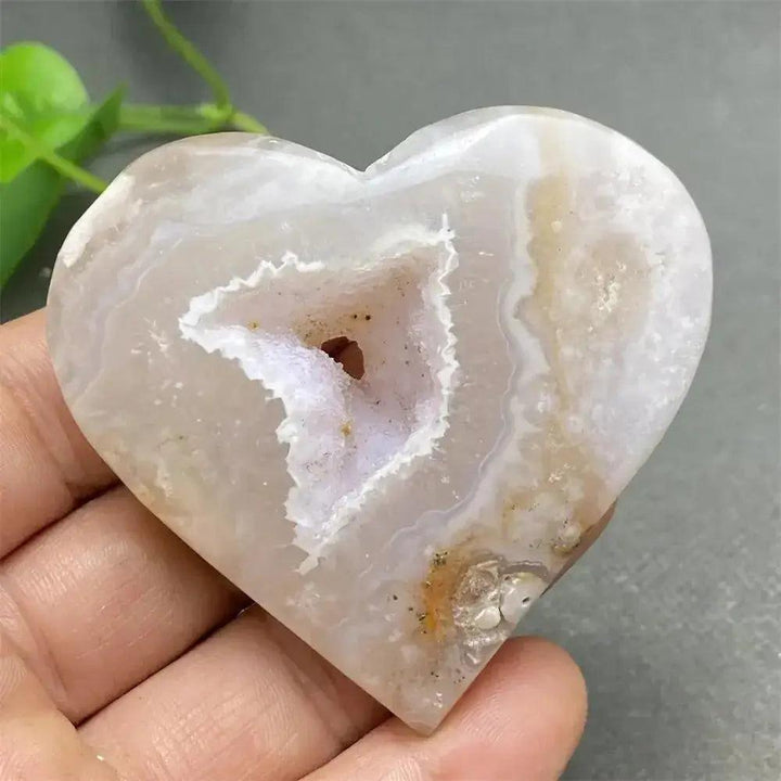 Polished Cherry Blossom Agate Heart with unique pink and white floral patterns and a sparkling geode center, promoting self-love.