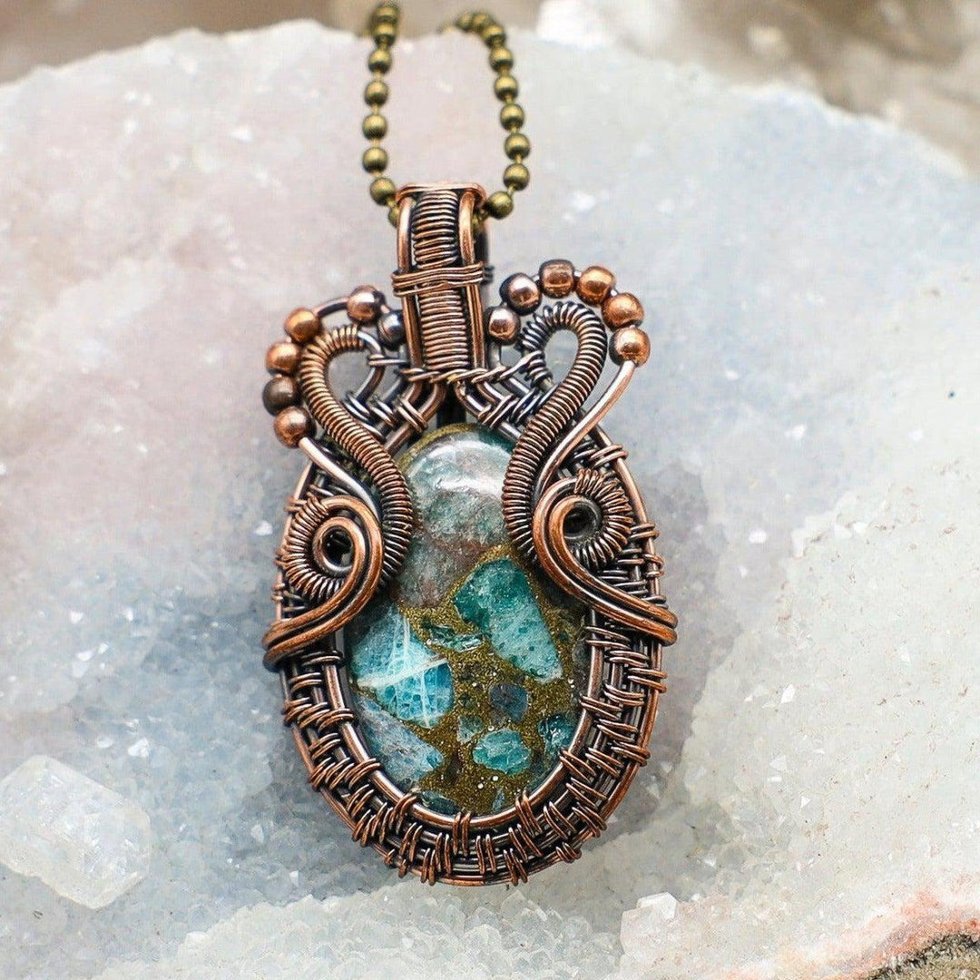 Chrysocolla Wire Wrap Crystal Pendant: Blue-green stone in intricate copper wire, promoting communication & goddess energy.