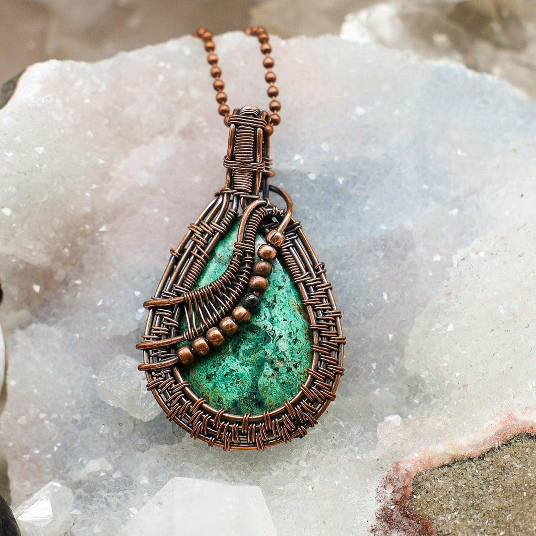 Stunning Chrysocolla teardrop pendant, wire-wrapped in healing copper, showcasing vibrant turquoise, blue, and green hues.