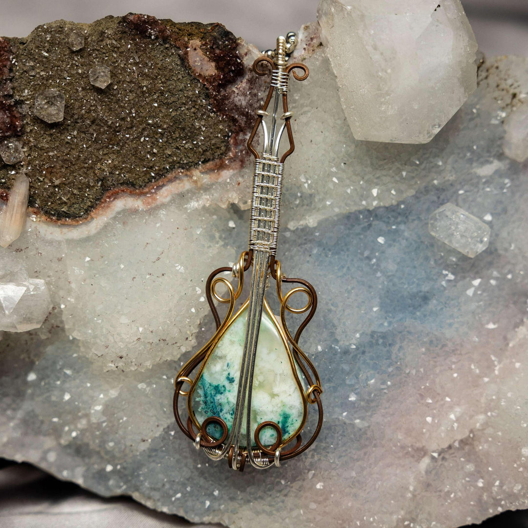 Striking Chrysocolla Quartz guitar wire wrap pendant, handcrafted copper, enhancing communication and empowerment.