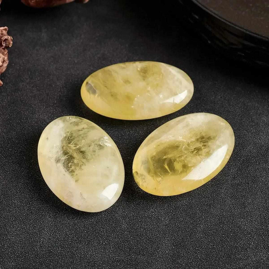 Three polished natural Citrine palm crystals with a smooth, golden yellow finish for Reiki healing and energy balancing.