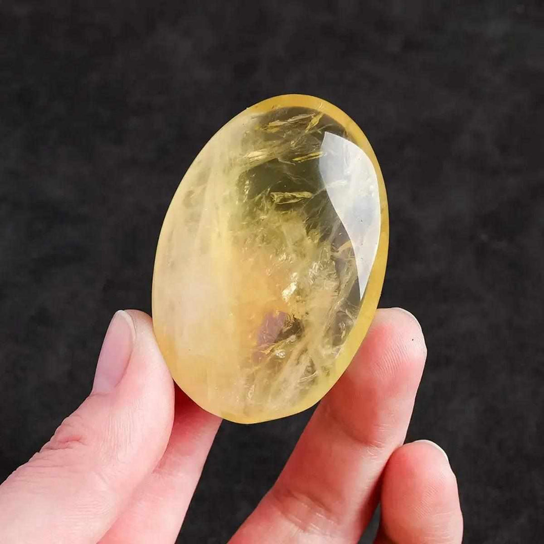 Polished natural citrine palm stone for Reiki healing, featuring a vibrant yellow quartz crystal for energy and home decor.