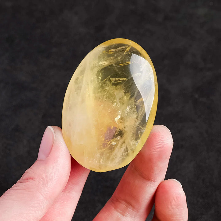 Polished natural citrine palm stone for Reiki healing, featuring a vibrant yellow quartz crystal for energy and home decor.