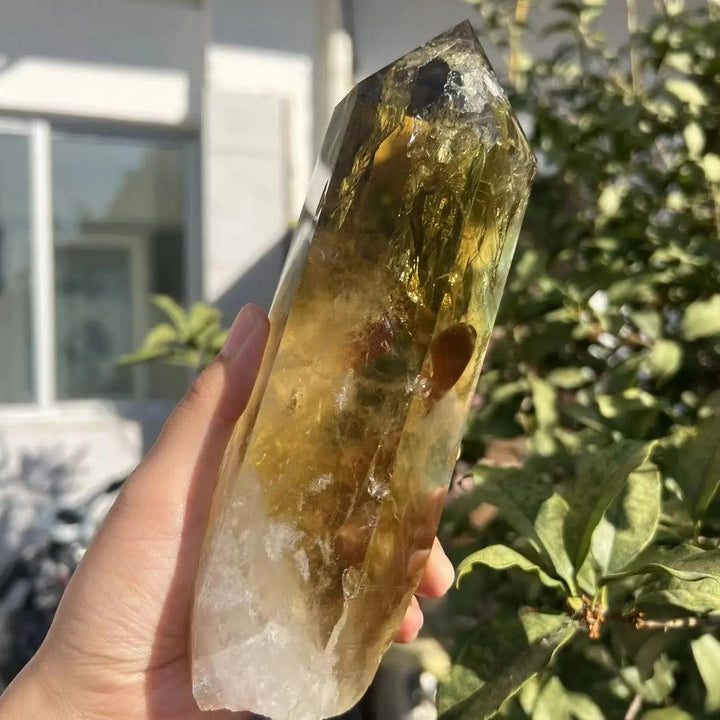 Handheld raw citrine quartz crystal point with a warm golden hue, natural termination, and vibrant manifestation energy.