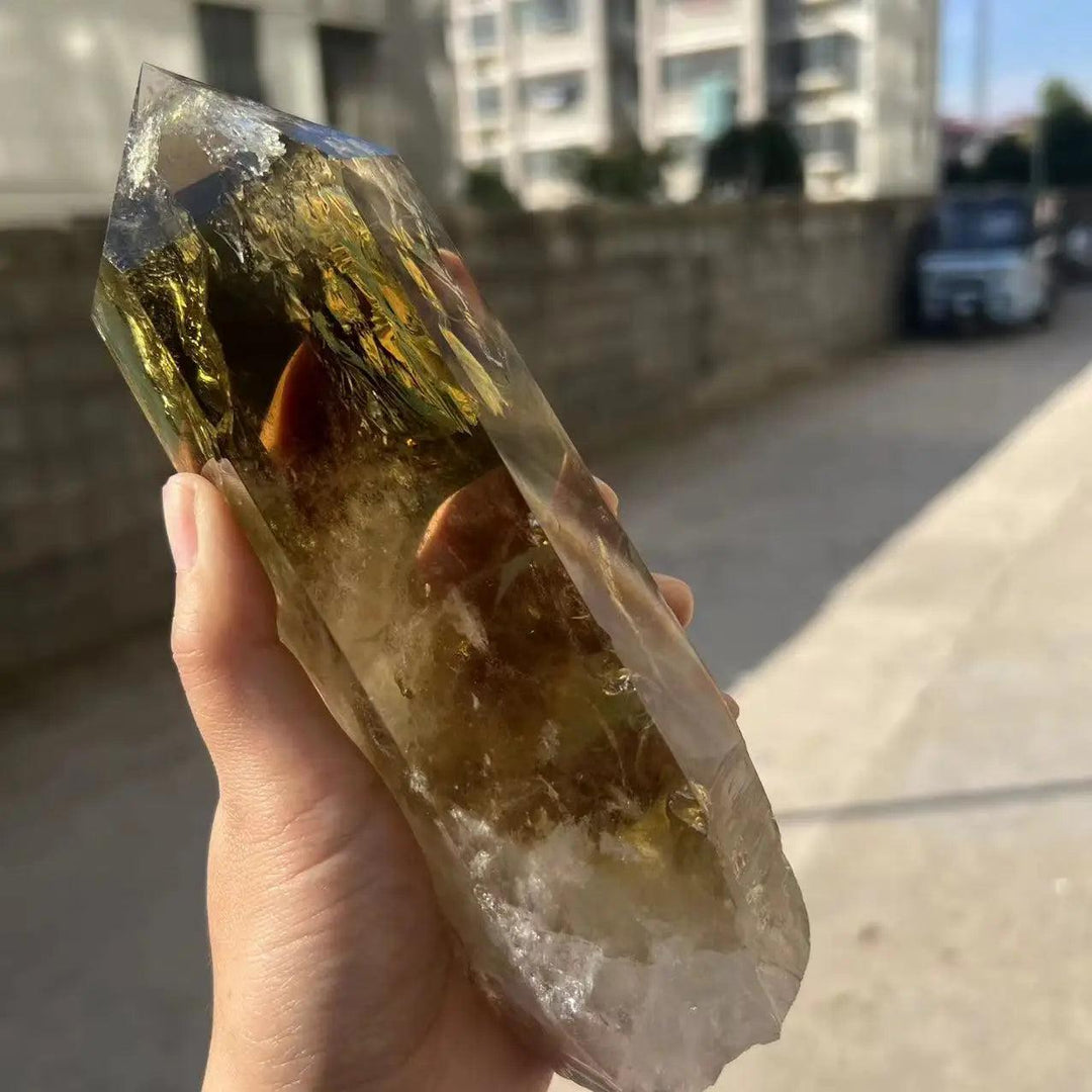 Handheld raw Citrine Quartz crystal point with golden hues and natural terminations for manifestation and energy.