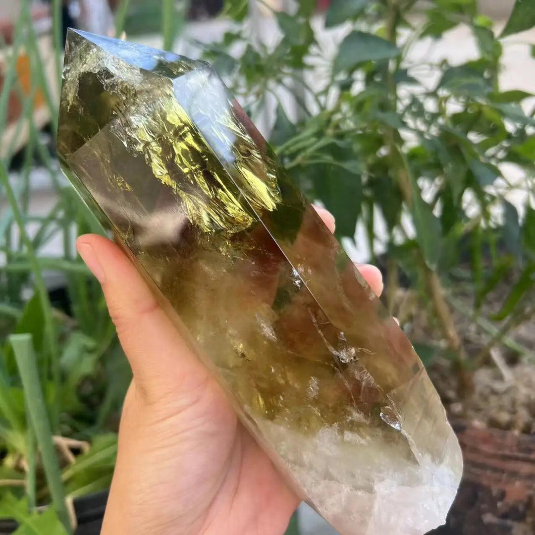 Handheld raw Citrine Quartz crystal point featuring a natural golden hue and unique inclusions for manifestation energy.