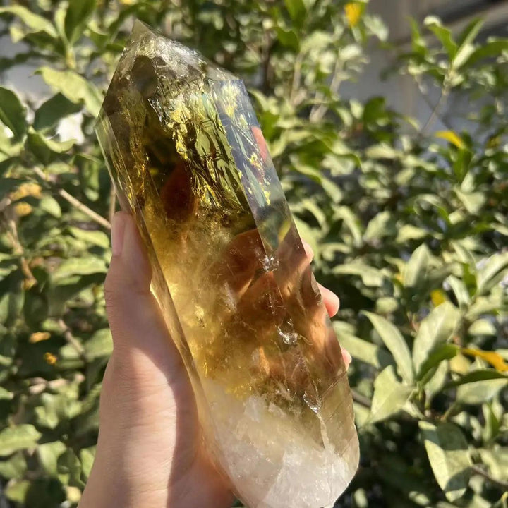 Handheld raw Citrine Quartz crystal point with golden hues and natural terminations for manifestation and energy.