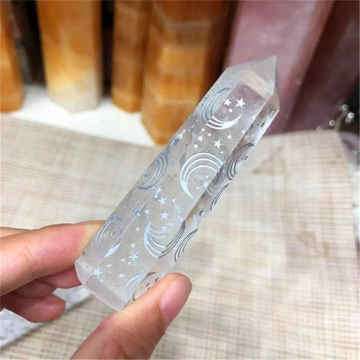 Clear quartz tower wand featuring engraved moon and star runes for spiritual healing and celestial energy.