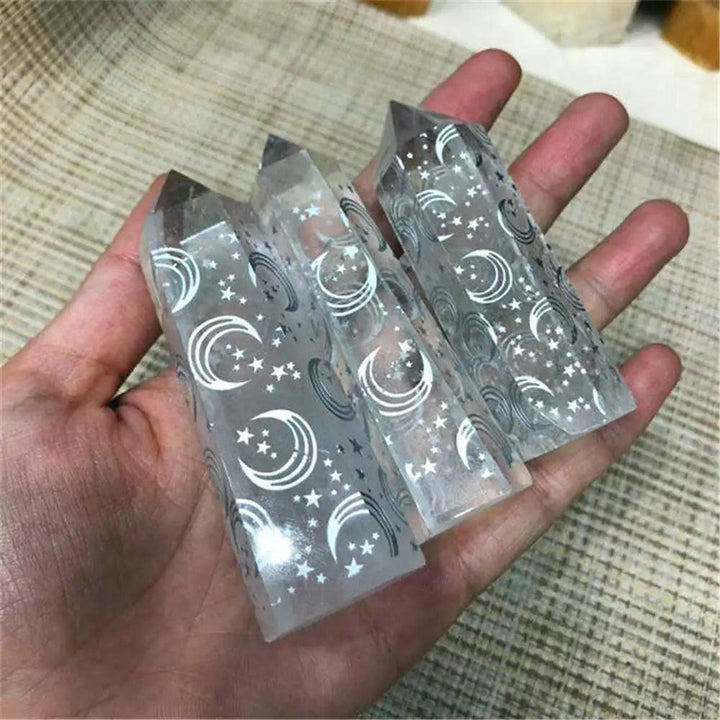 Clear quartz healing wands carved with celestial moon and star designs for spiritual energy and crystal meditation.