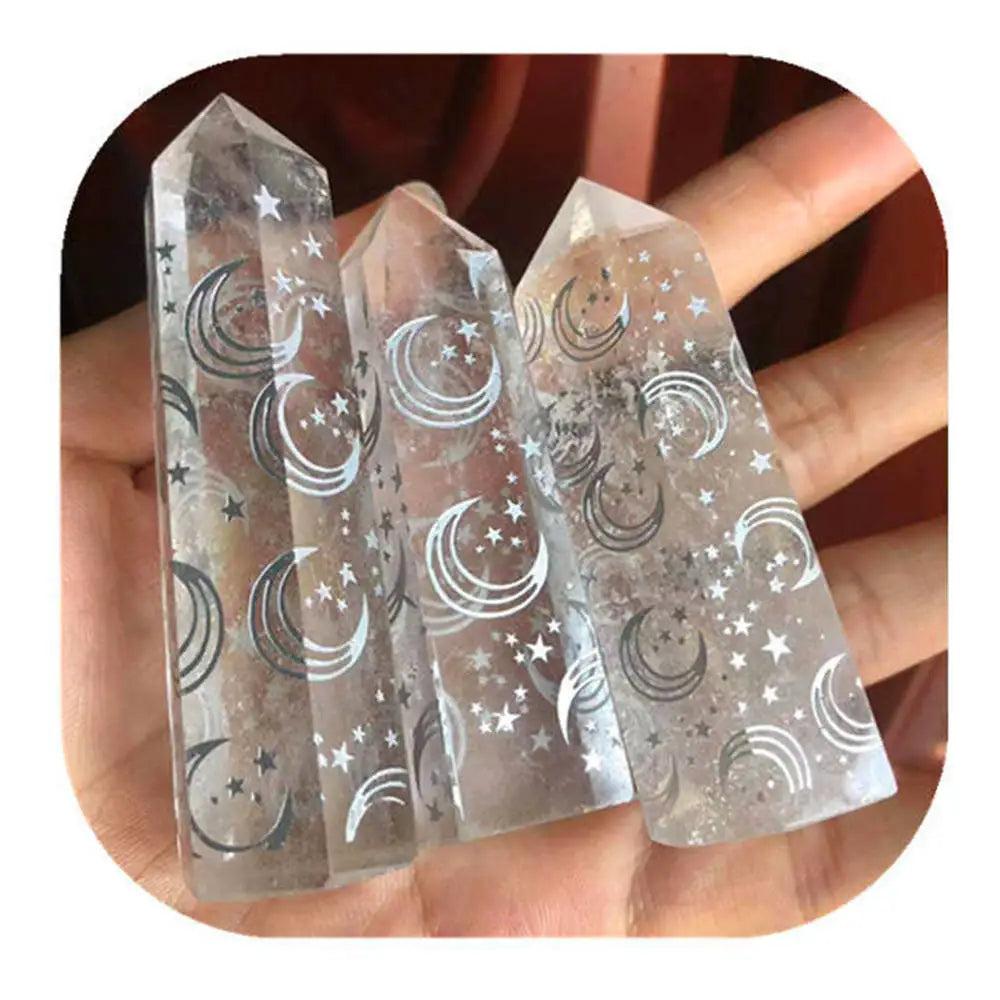 Natural clear quartz crystal tower wand featuring etched moon and star designs for spiritual healing and energy work.