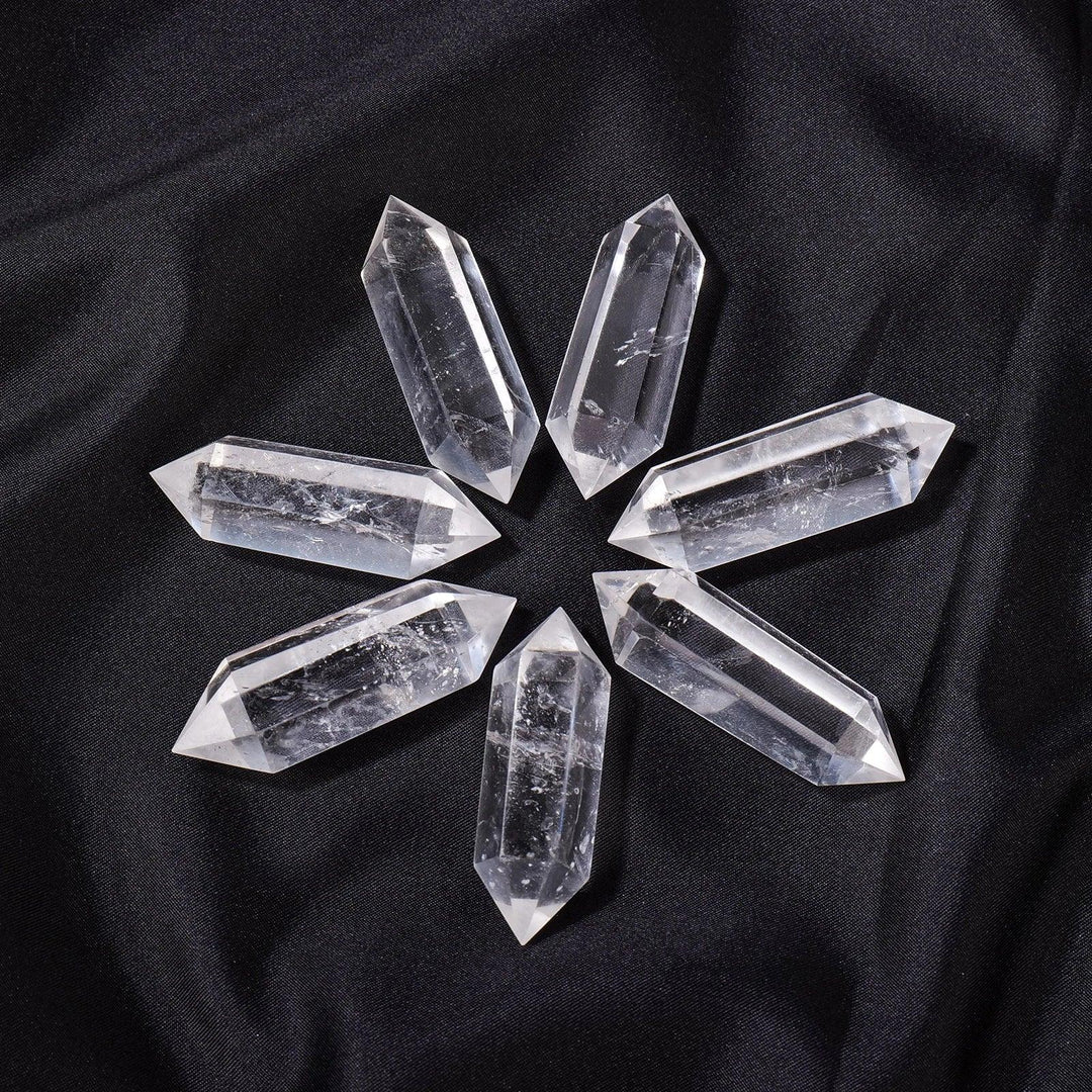Clear Quartz Crystal Double Terminated Point, a powerful tool for manifestation and healing, arranged on black fabric.