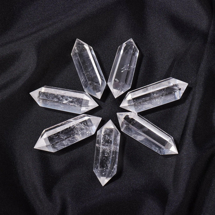 Clear Quartz Crystal Double Terminated Point, a powerful tool for manifestation and healing, arranged on black fabric.