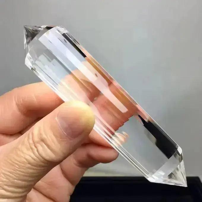 Clear Quartz Crystal Double Terminated Vogel Healing Wand, held by hand, showcasing its pure clarity and faceted design.
