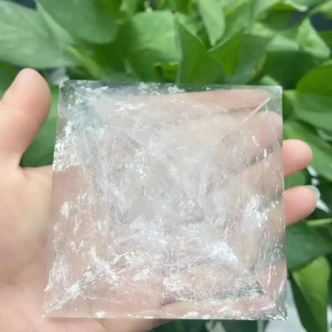Clear Quartz Crystal Pyramid Natural Amplifier Stone, a polished, transparent pyramid held in a hand.