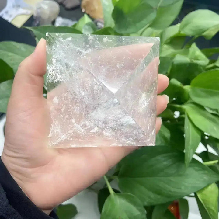 Clear Quartz Crystal Pyramid Natural Amplifier Stone, a translucent, polished pyramid held in a hand, enhancing focus.