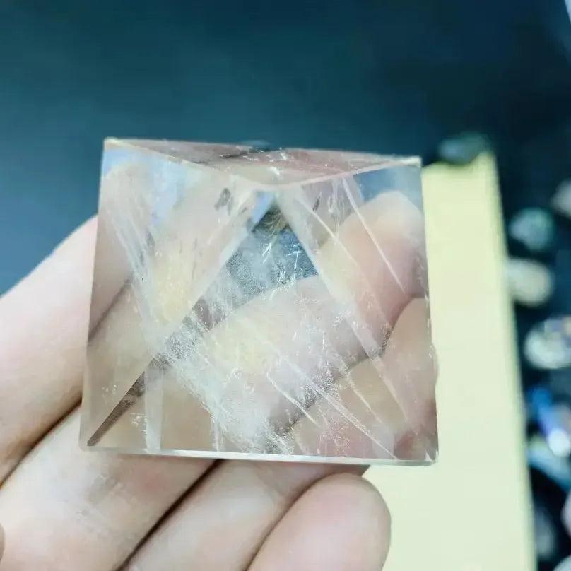 Clear Quartz Crystal Destiny pyramid, polished, transparent with natural inclusions, held in hand.