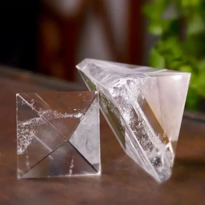 Clear quartz crystal pyramid for chakra healing and meditation, with natural inclusions.