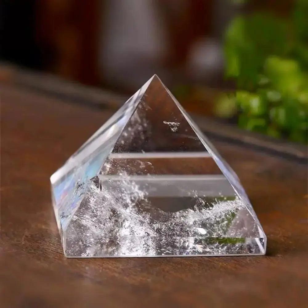 Clear quartz crystal pyramid for chakra healing and meditation, featuring natural inclusions.