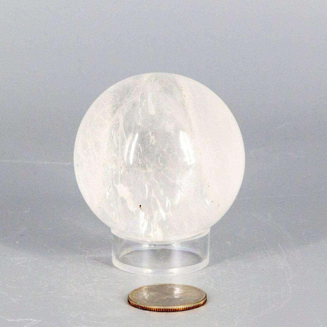 Natural Quartz Sphere Master Healer, 53-55mm, clear polished crystal with unique inclusions on a stand.