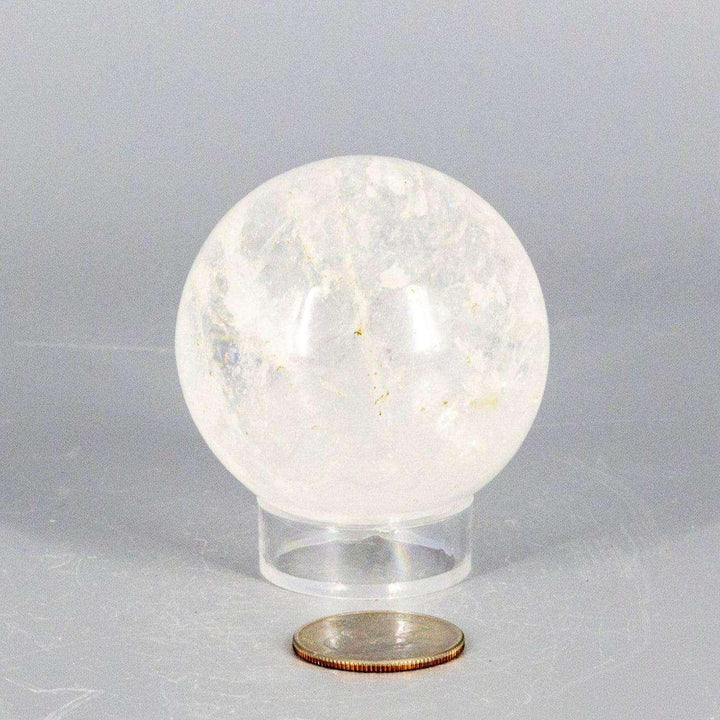 Natural Quartz Sphere Master Healer, 53-55mm, clear polished crystal ball on stand, next to a coin.