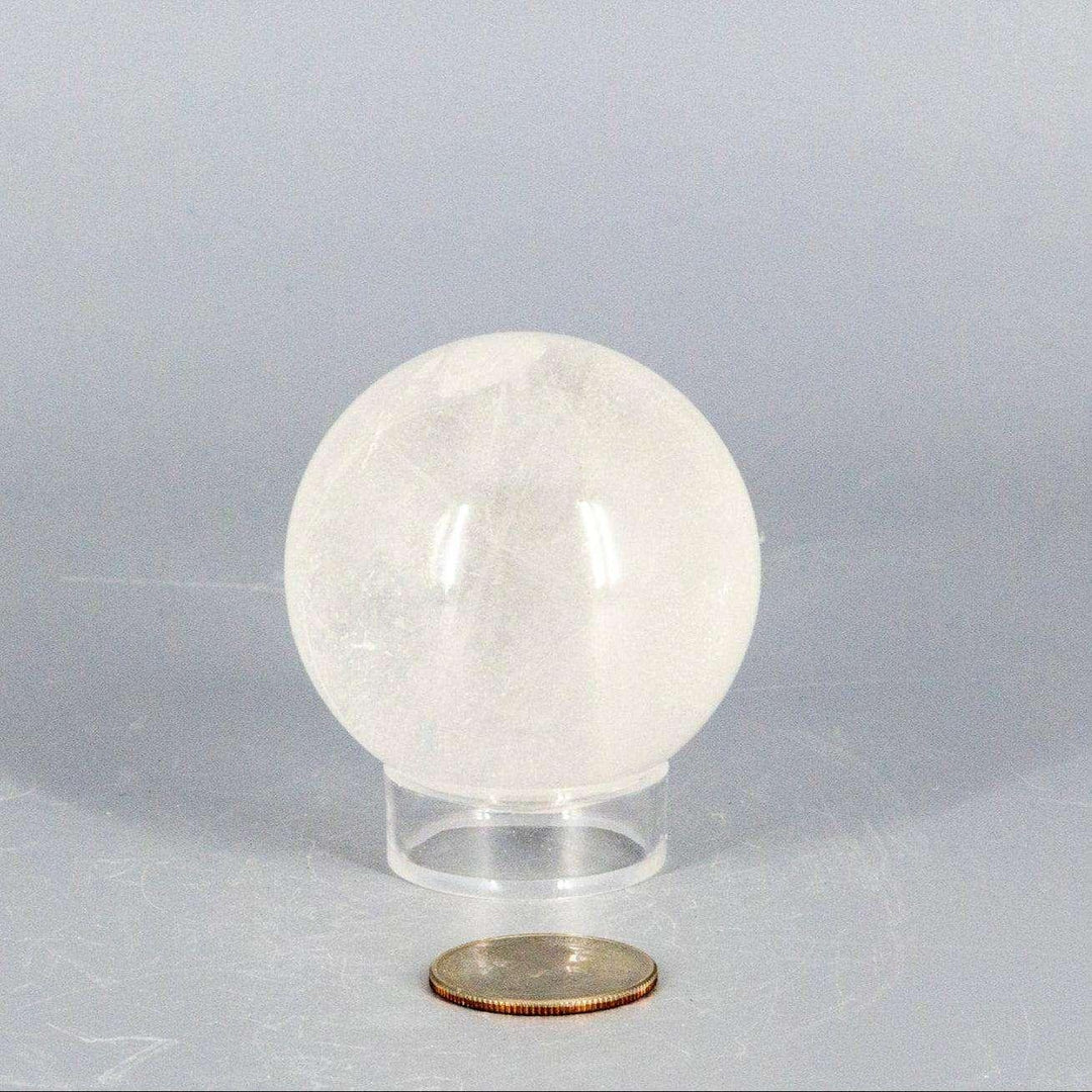 Natural Quartz Sphere Master Healer, 53-55mm, clear polished crystal with unique inclusions on a stand.