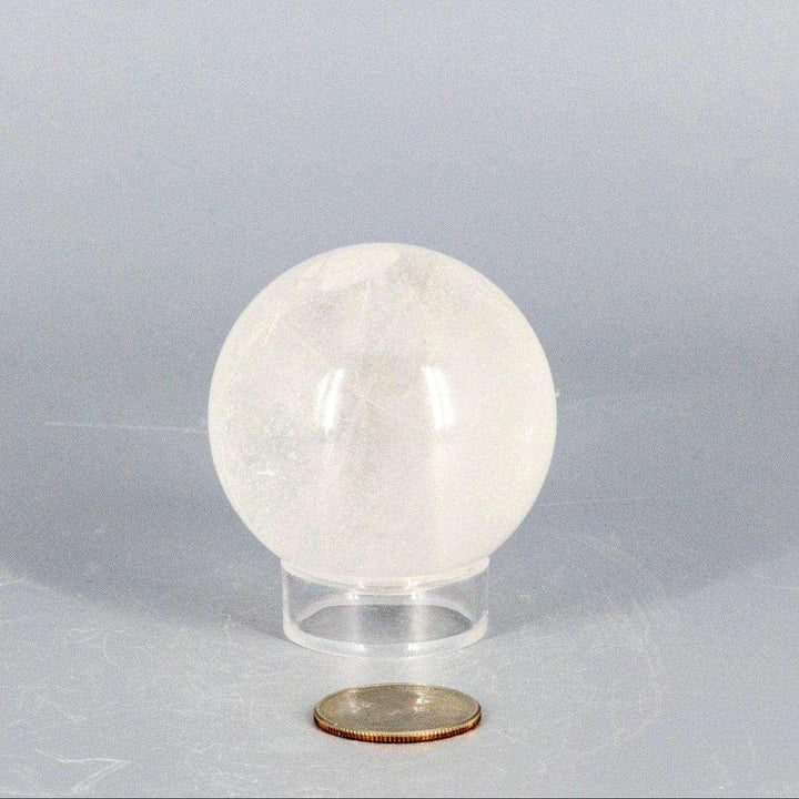 Natural Quartz Sphere Master Healer, 53-55mm, clear polished crystal with unique inclusions on a stand.