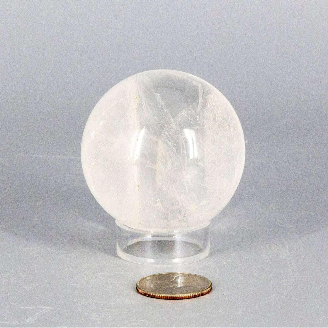 Natural Quartz Sphere Master Healer, 53-55mm, clear polished crystal with internal features on a stand.