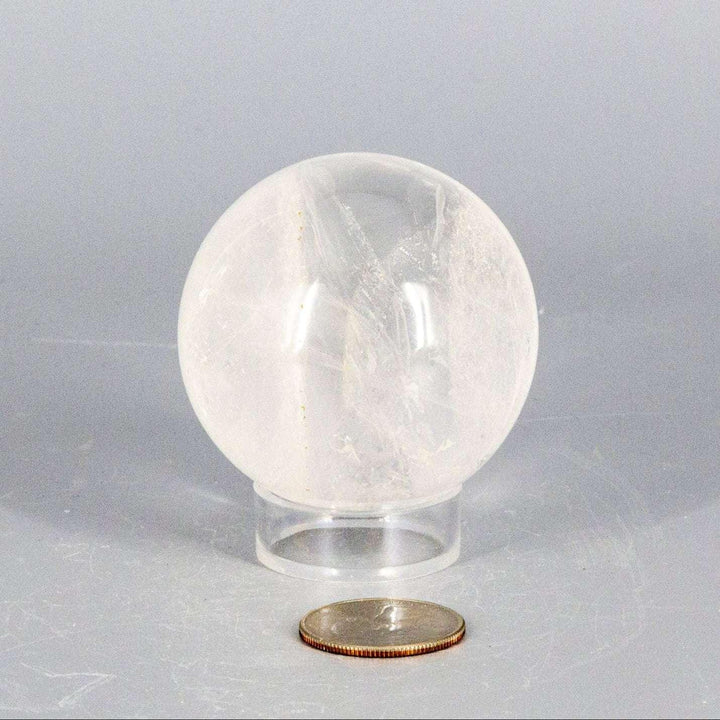 Natural Quartz Sphere Master Healer, 53-55mm, clear polished crystal with internal features on a stand.