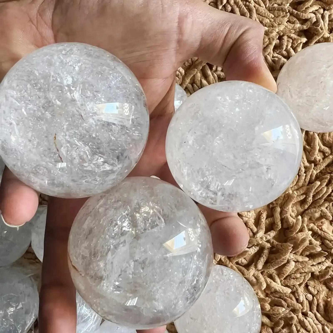 Polished Clear Quartz crystal spheres with internal veils and reflective textures for Crown Chakra meditation.