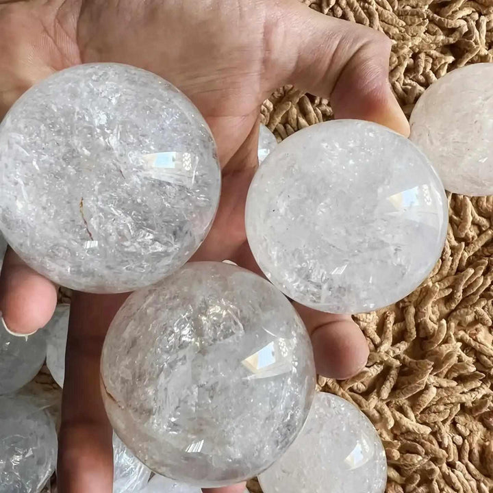 Polished Clear Quartz crystal spheres with internal veils and reflective textures for Crown Chakra meditation.