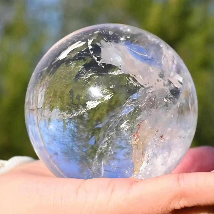 Polished Clear Quartz Crystal Sphere with internal veils and cloudy textures, perfect for Crown Chakra meditation.